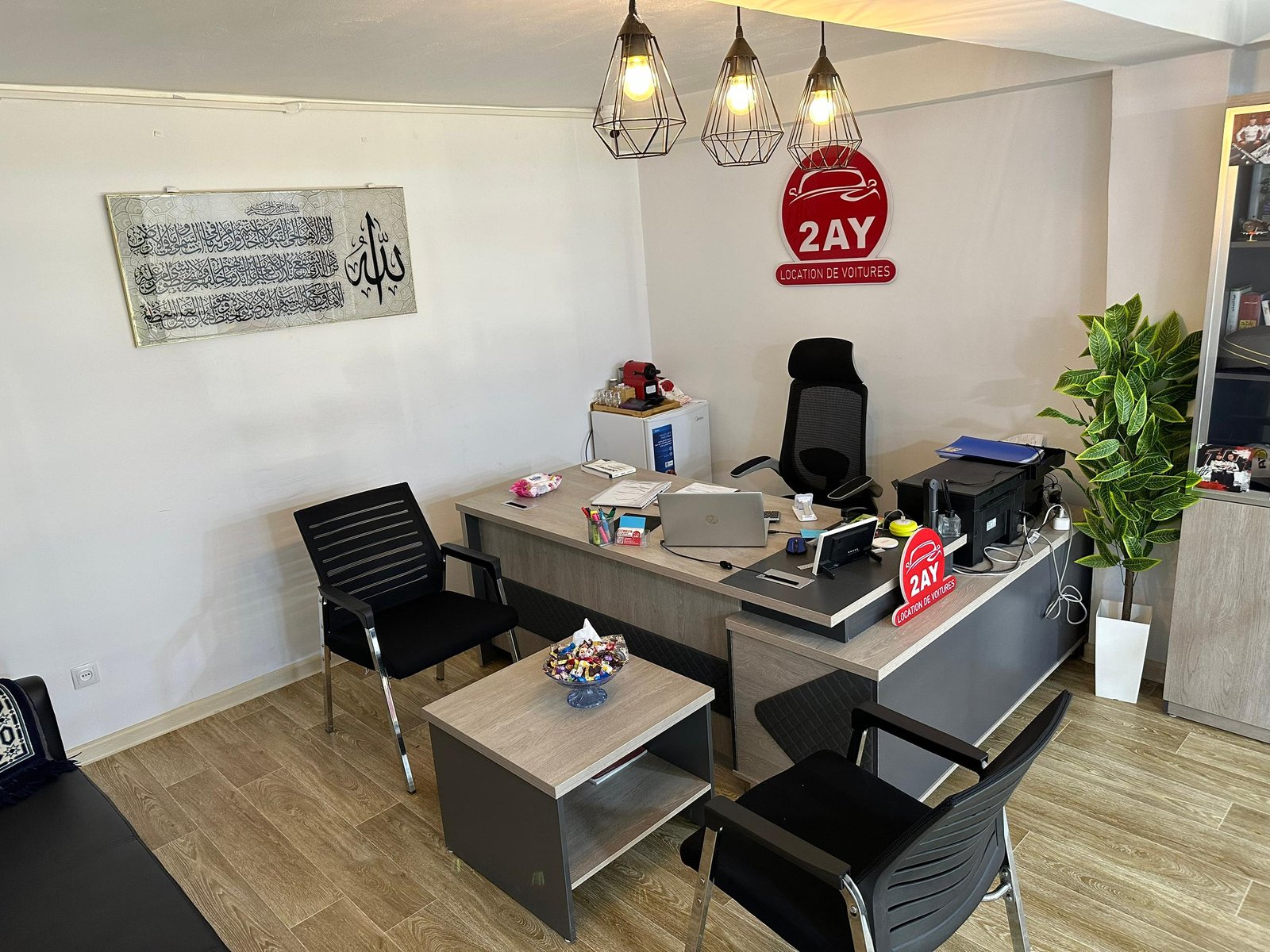 Intérieur de l'agence 2AY Location De Voitures à Sétif — bureau d'accueil avec logo 2AY, chaises clients et espace de travail, El-Maabouda Sétif 19000